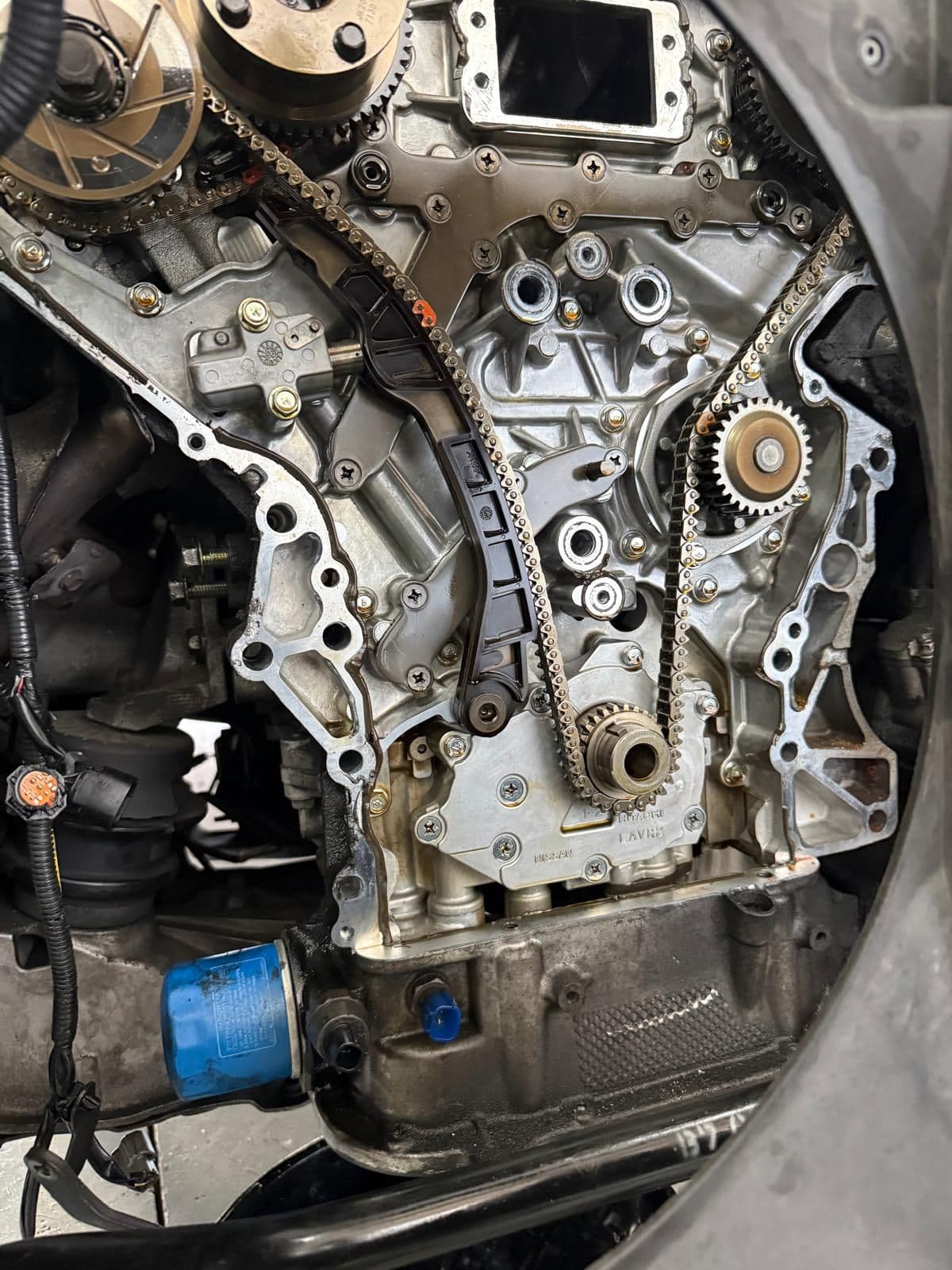 An engine with its front cover removed to expose the timing chain and sprockets during a mechanical repair at the Regal Automotive workshop